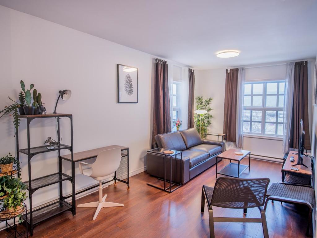 a living room with a couch and a table at Appartements Victoria in La Baie