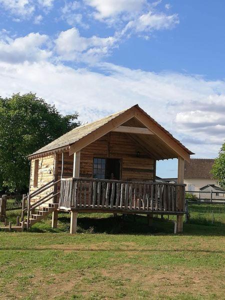 małą drewnianą kabinę z werandą na polu w obiekcie LA CABANE DE JABI w mieście Trémont