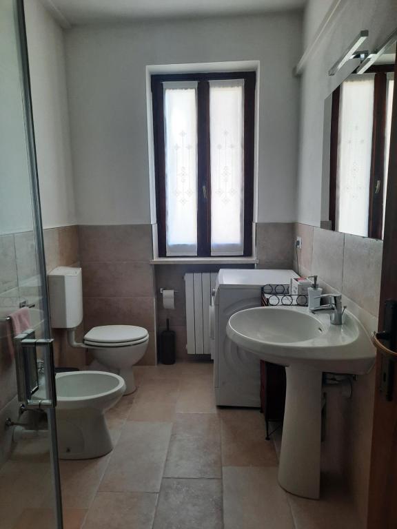 łazienka z 2 umywalkami, toaletą i lustrem w obiekcie Mary House w mieście Negrar