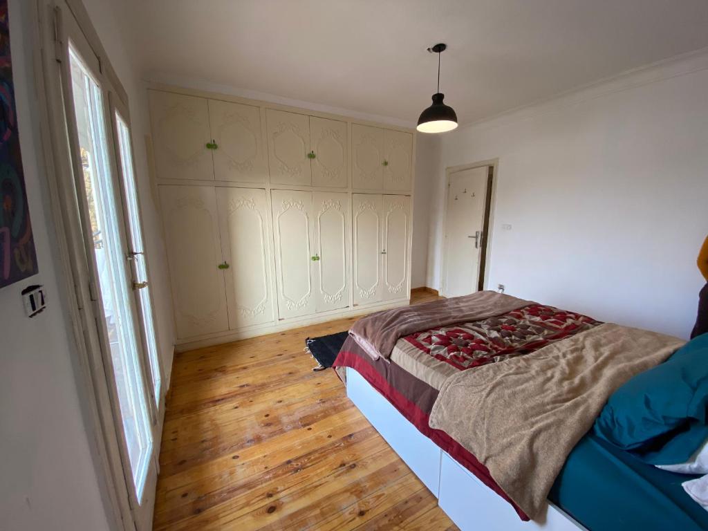 1 dormitorio con 1 cama y suelo de madera en Cozy Room with an amazing view in Maadi, en El Cairo