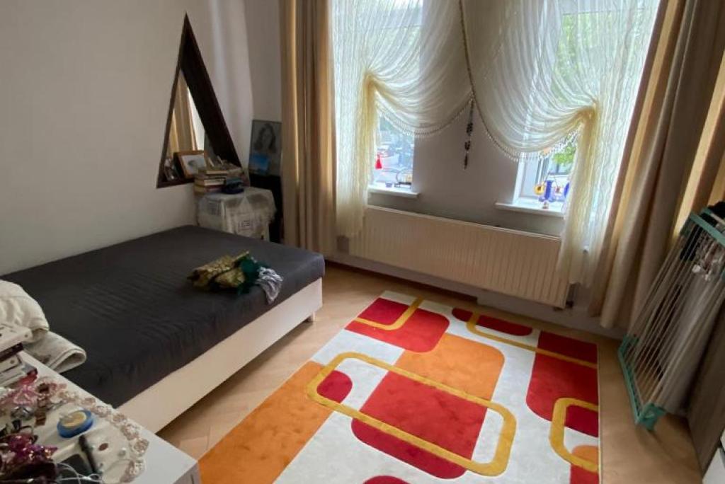 een slaapkamer met een bed en een tapijt op de vloer bij ID 7063 - Private Apartment in Hannover