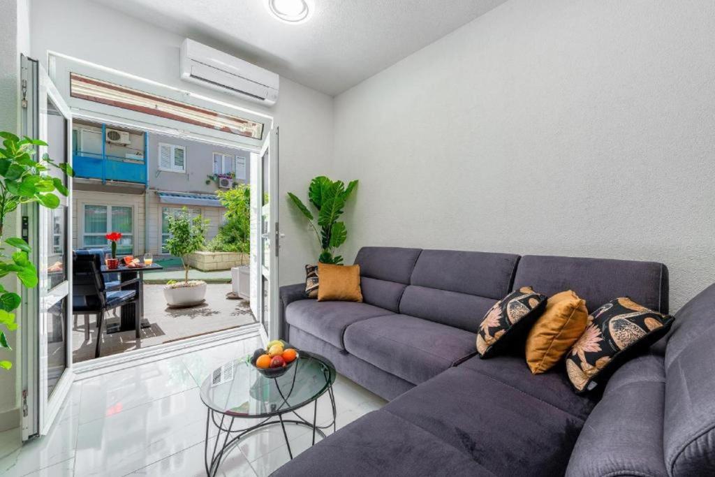 Una sala de estar con un sofá azul y una mesa de cristal. en Apartment Zolla Dubrovnik- Hot Tub and Free Parking, en Dubrovnik