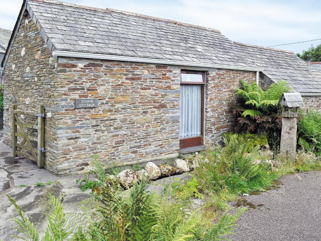 a brick building with a sign in front of it at Stable in Delabole