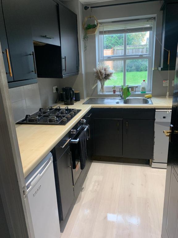 a kitchen with a stove and a sink and a window at Stylish Darlington Townhouse Near A1 A66 & A19 Breakfast in Darlington