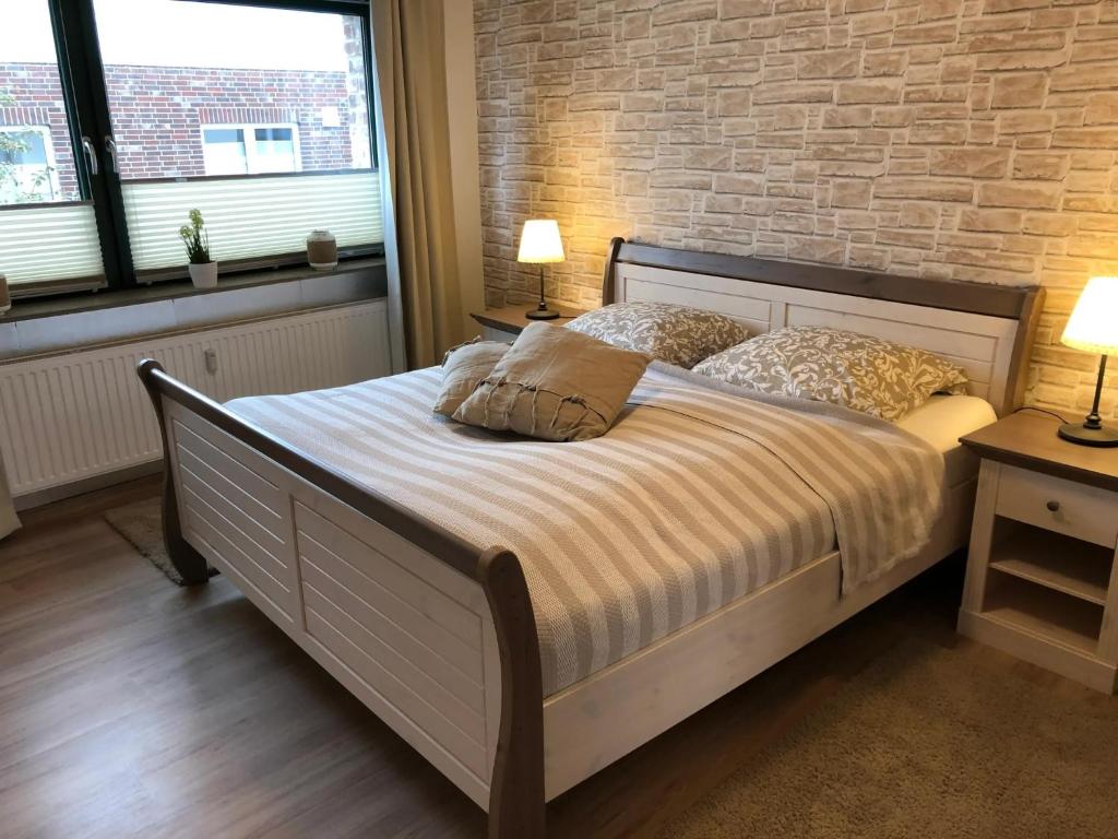 Fewo 1 في Nortorf: سرير في غرفة نوم مع جدار من الطوب