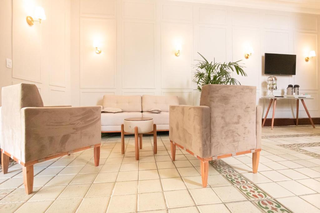 a living room with two chairs and a couch at Pousada Catedral in Petrópolis