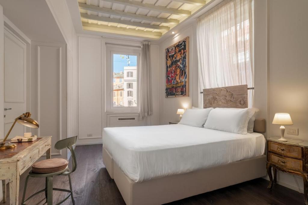 sypialnia z białym łóżkiem, biurkiem i oknem w obiekcie BDB Rooms Trastevere w Rzymie