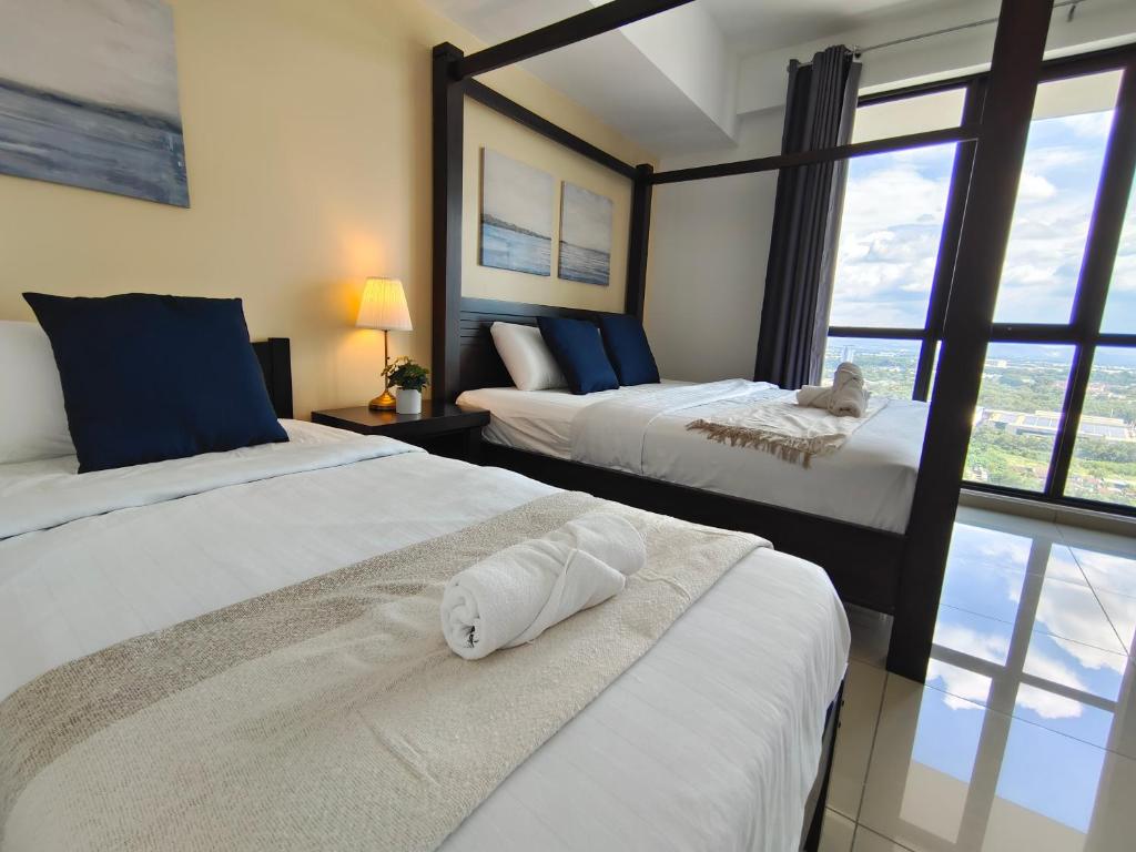 um quarto de hotel com duas camas e uma janela em 【NEW】Cozy&Warm Studio@Juru Sentral Icon City em Bukit Mertajam