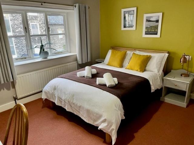 a bedroom with a bed with two towels on it at Courtyard Flat - Kendal in Kendal