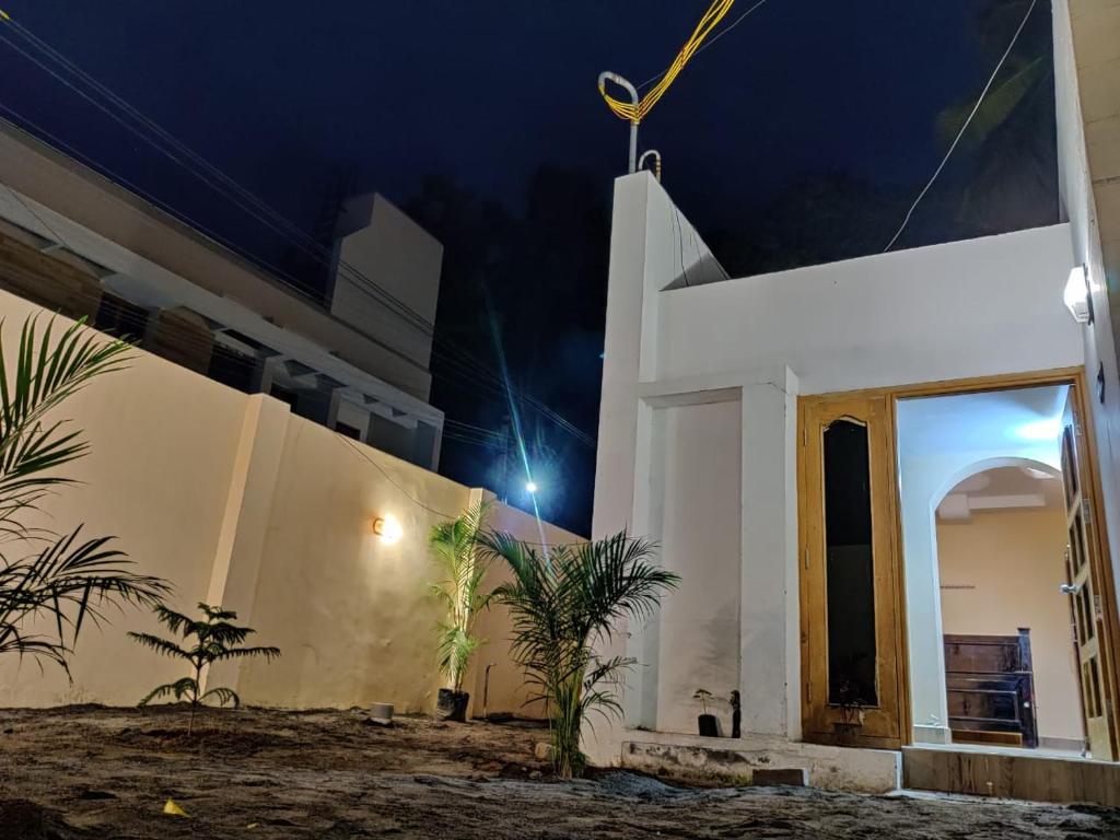 een wit gebouw met 's nachts een deur bij Le Grace Annanagar in Madurai