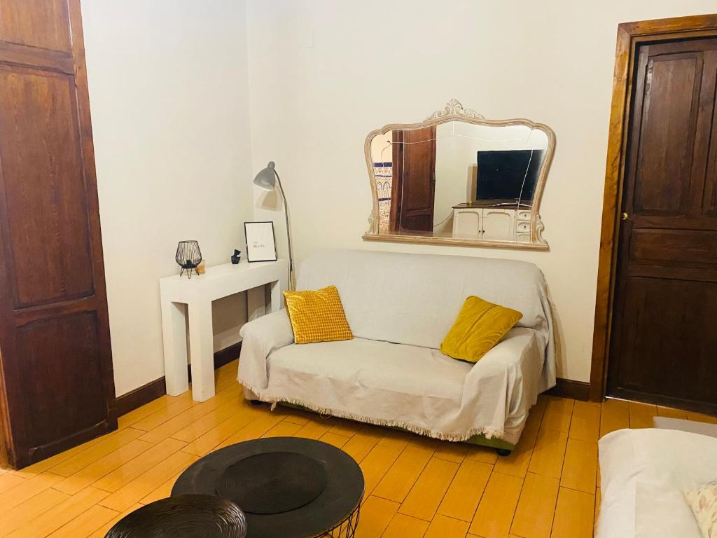 a living room with a couch and a mirror at Casita de pueblo in Benicàssim