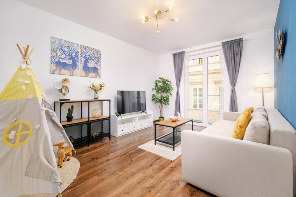 ein Wohnzimmer mit einem weißen Sofa und einem TV in der Unterkunft Erkel Fairy Home in Budapest