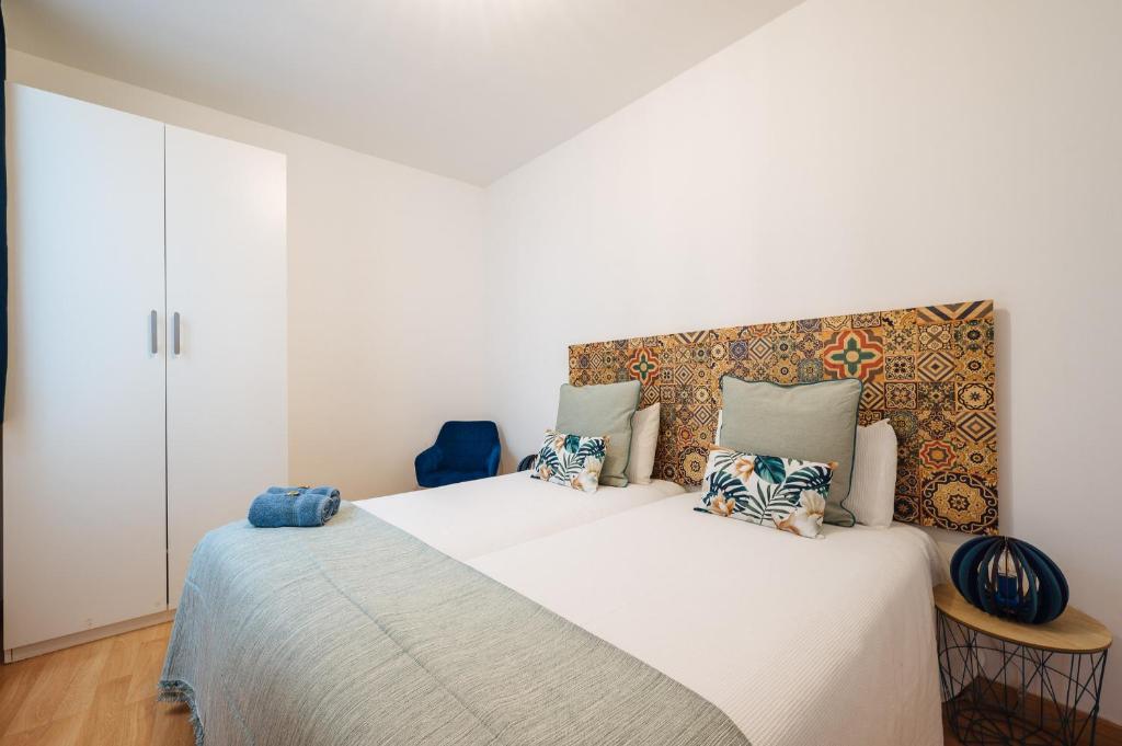 ein Schlafzimmer mit einem großen weißen Bett mit Kissen in der Unterkunft Apartamento exclusivo junto a la catedral de Sevilla in Sevilla