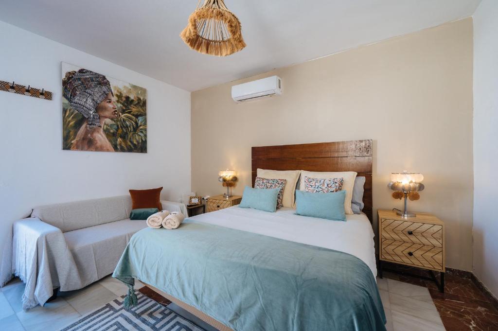 ein Schlafzimmer mit einem Bett und einer Couch in der Unterkunft Ático lujo junto a la catedral. Giralda in Sevilla