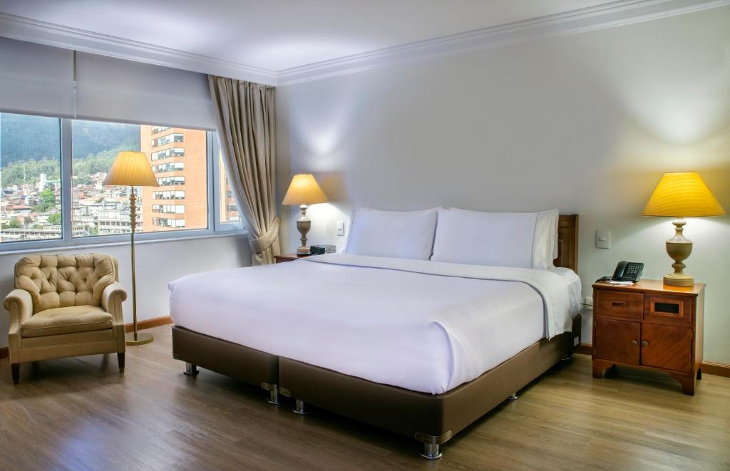 a bedroom with a bed and a chair and a window at GHL Hotel Tequendama Bogotá in Bogotá