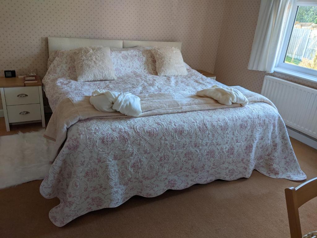 a bedroom with a bed with two pillows on it at Hazler Lodge in Church Stretton