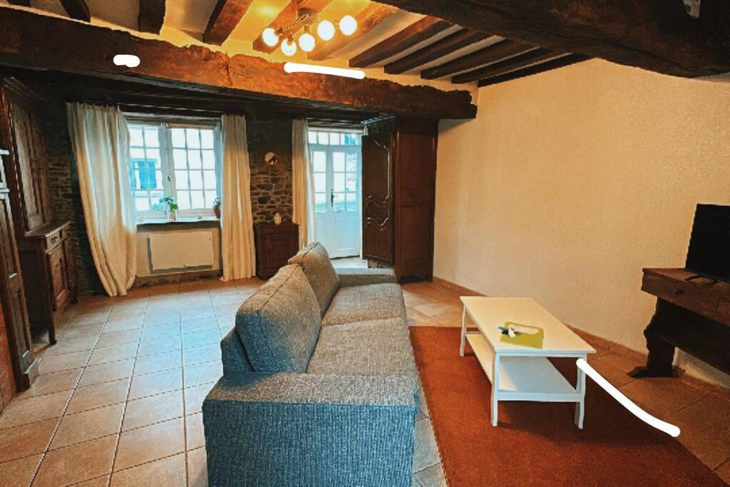 sala de estar con sofá y mesa en Chez Alice - Isigny le Buat, en Isigny-le-Buat