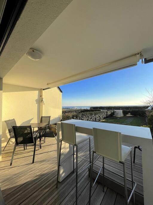 un balcon avec une table et des chaises sur une terrasse dans l'établissement Appartement bord de Mer ・Le rivage・, à Piriac-sur-Mer