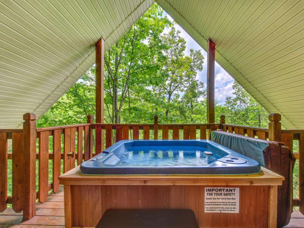 bañera de hidromasaje en la cubierta de una casa en Macys Hideaway, 1 Bedroom, Hot Tub, WiFi, Sleeps 7, en Sevierville