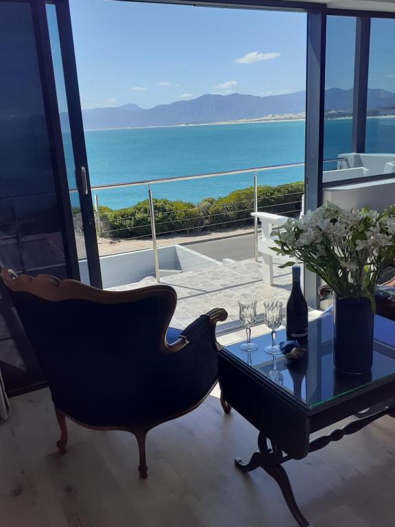 ein Wohnzimmer mit einem Tisch und einem Stuhl in der Unterkunft 65onCliff in Gansbaai