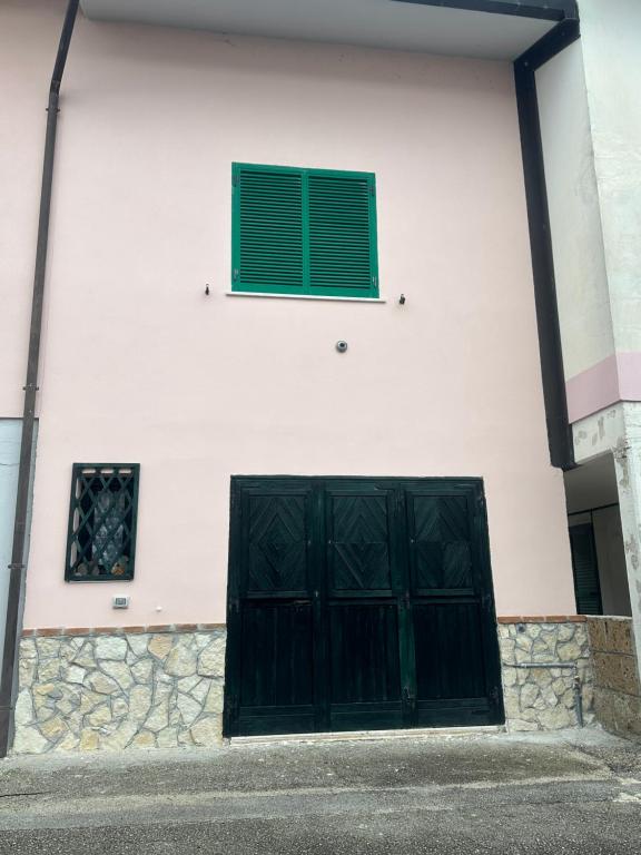 un edificio con dos puertas negras y una ventana en Relax home en San Massimo