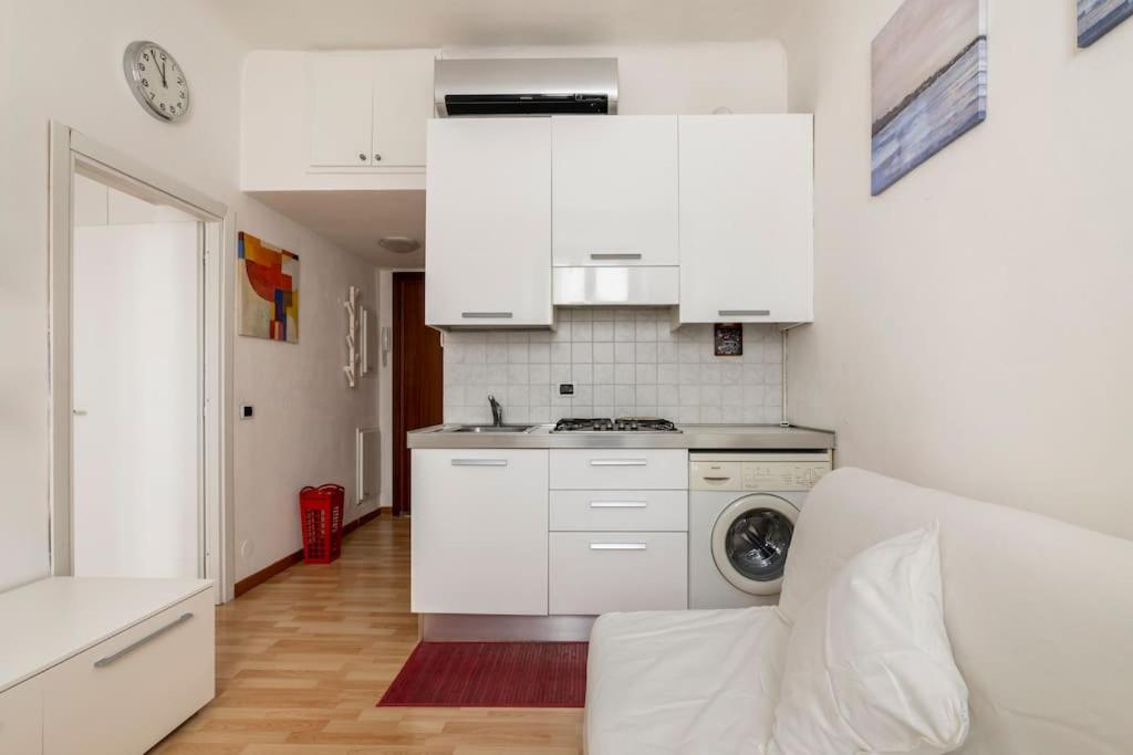 een keuken met witte kasten en een wasmachine bij Papi12 in Milaan