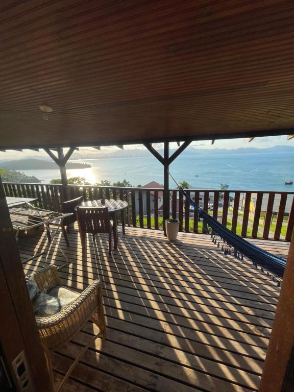 una terraza con bancos y vistas al océano. en Casa deck caixa d´aço, en Porto Belo