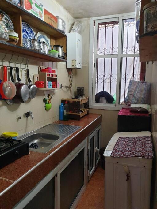 a small kitchen with a sink and a window at location nuit pour les familles in Settat