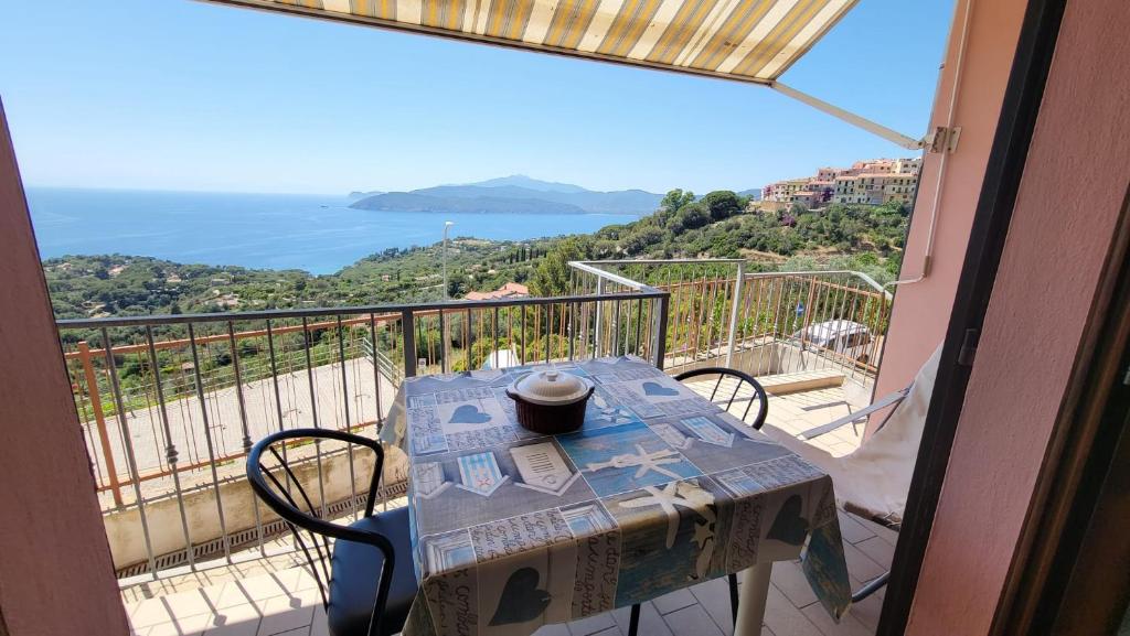 a table on a balcony with a view of the ocean at Appartamento Bellavista in Capoliveri