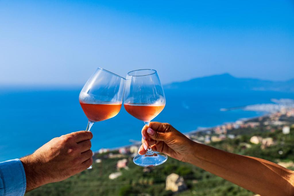 dos personas sosteniendo copas de vino en sus manos en Olivenere agriturismo, en Lavagna