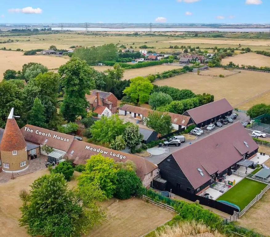 una vista aérea de un pequeño pueblo con una iglesia en The Roost Group - 29 Guests - Two Luxury Barns, en Gravesend