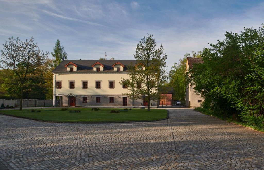 een groot wit huis met een oprit bij Penzion Velký mlýn in Hlučín