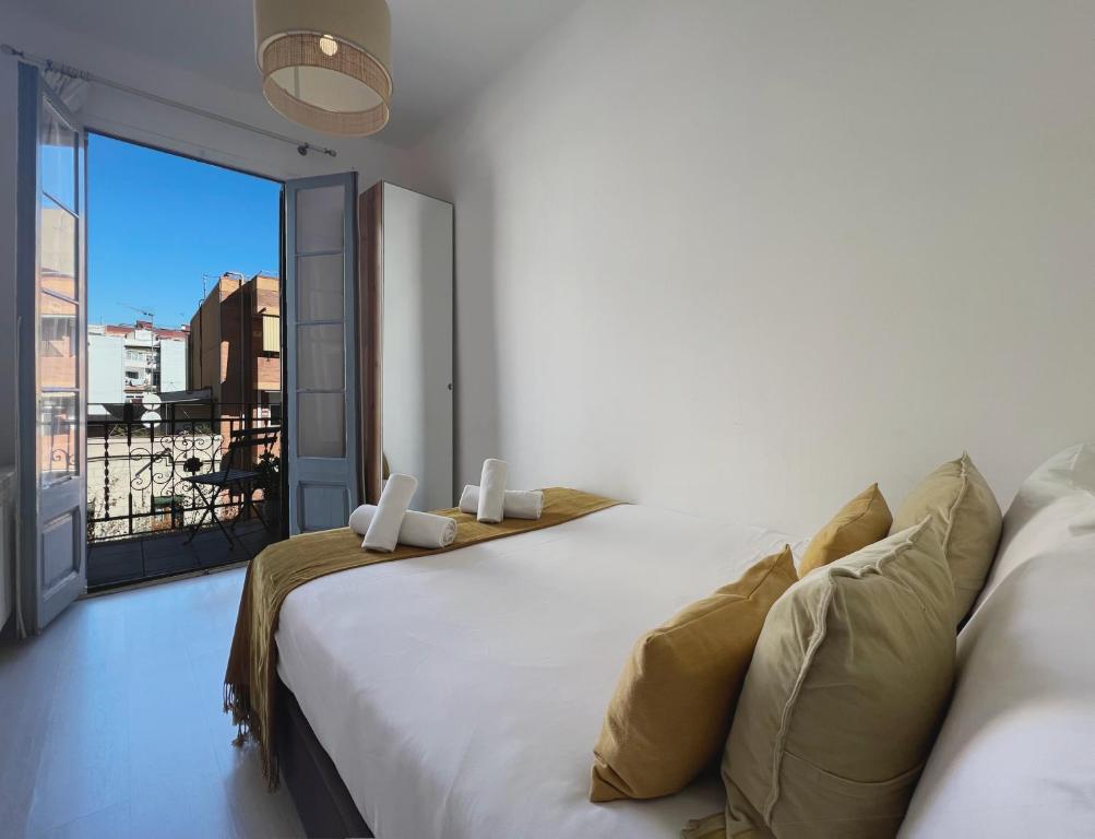 um quarto com uma grande cama branca e uma varanda em Stay U-nique Apartments Lepant em Barcelona