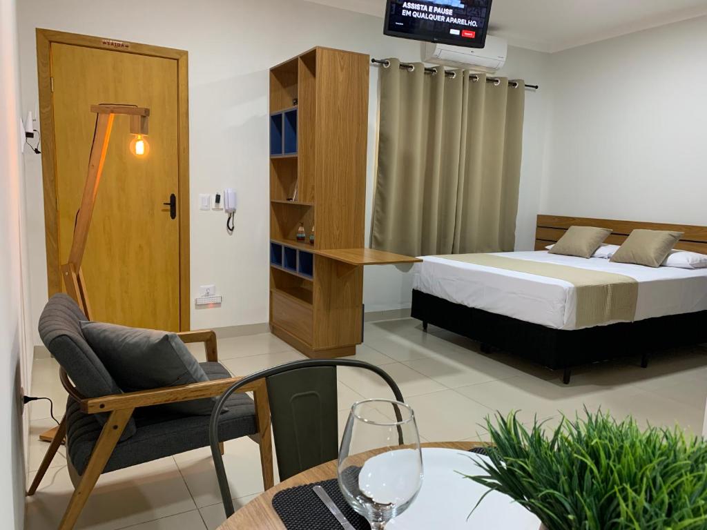 a hotel room with a bed and a table and chairs at Studio Standard Comfort I AO LADO SHOPPING in Três Lagoas