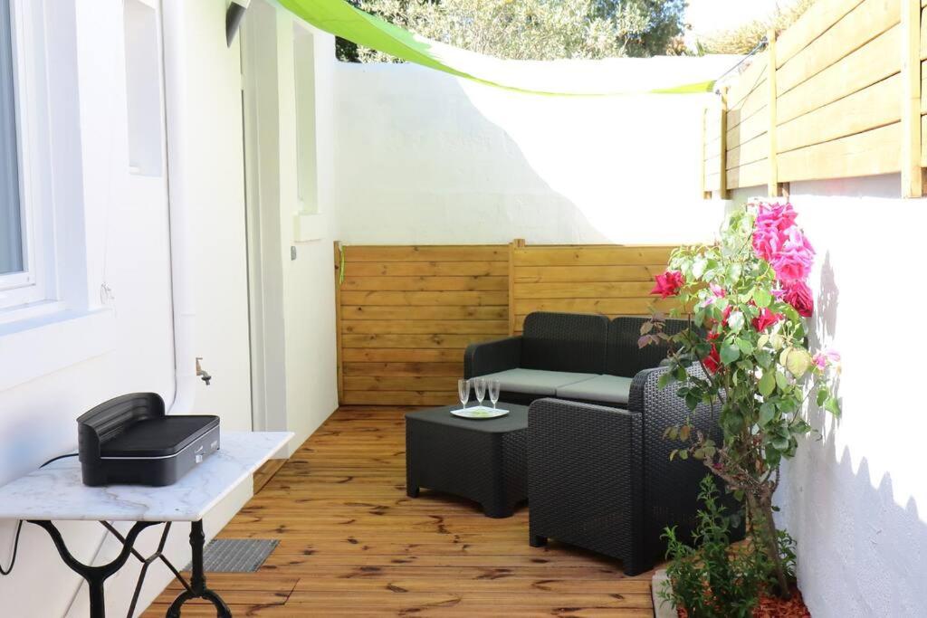 een patio met een bank en een tafel bij La Rose des Sables maison de pêcheur de 7 pers. in Les Sables-dʼOlonne