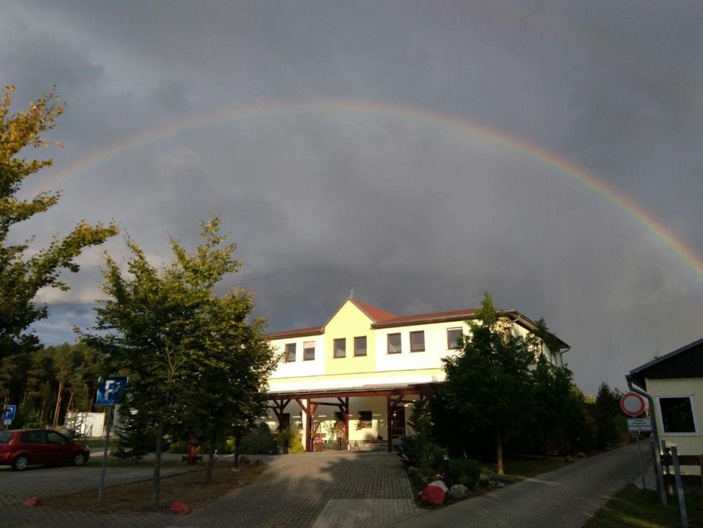 Ein Regenbogen am Himmel über einem Gebäude in der Unterkunft Ferienwohnung 2 in Schmogrow