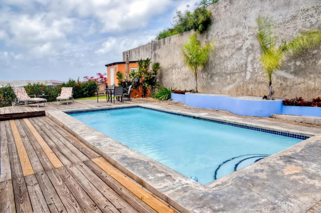 a swimming pool with a wooden deck next to a building at Vieques Island House with Caribbean Views and Pool! in Vieques