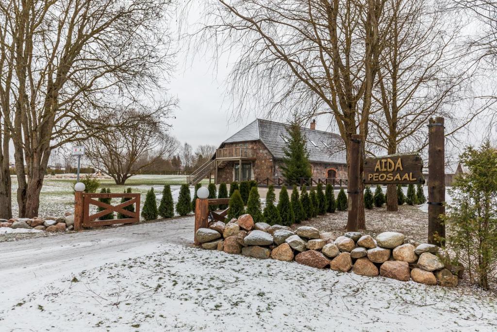 a barn in the snow in front of a house at Aida Apartment in Külitse