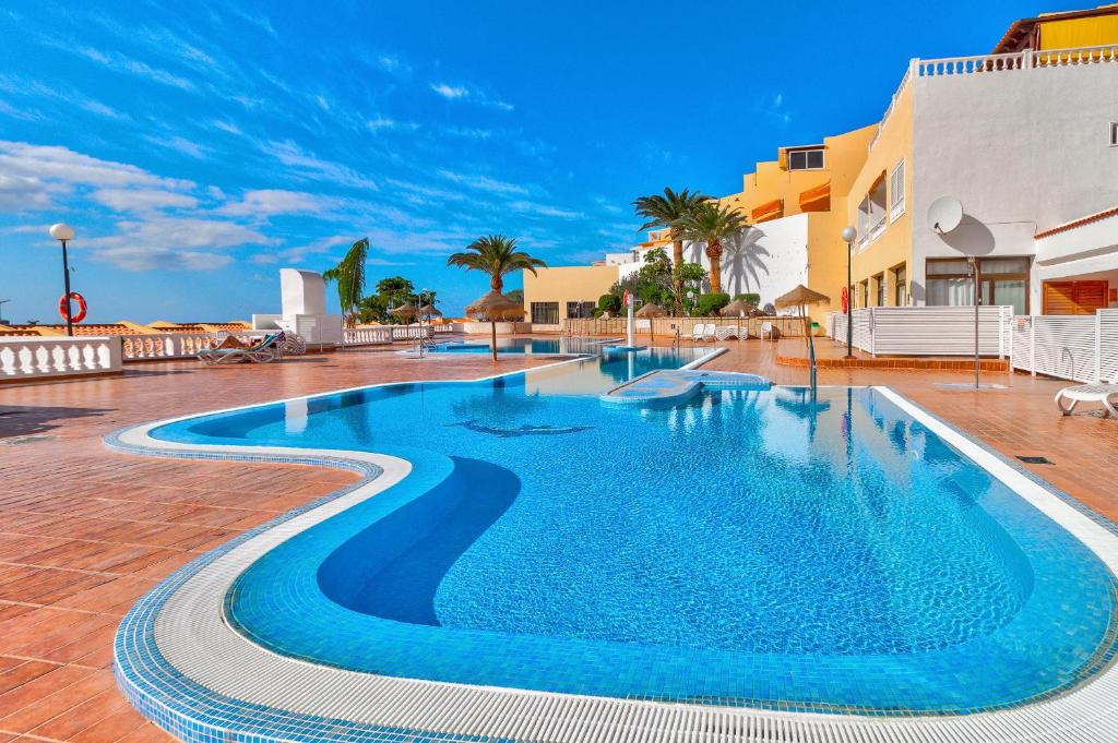 een zwembad met blauw water in een resort bij Las Brisas FREE WIFI in Adeje