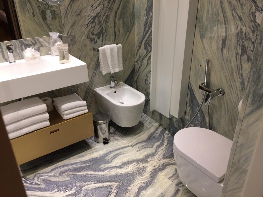a bathroom with a white toilet and a sink at Santa Croce Boutique Hotel in Venice