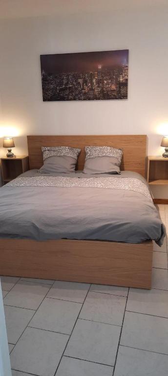 - un lit avec un cadre en bois dans une chambre dans l'établissement magnolia, appartement lumineux et agréable, à Arleux-en-Gohelle