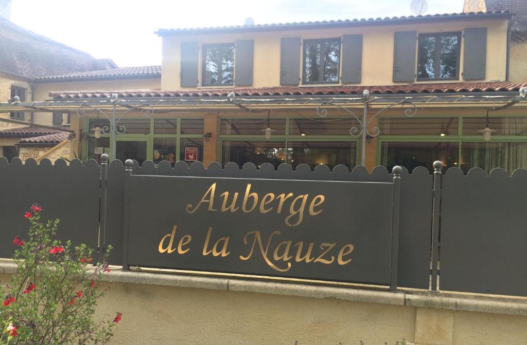 a sign on a fence in front of a building at Hôtel Auberge de La Nauze in Sagelat