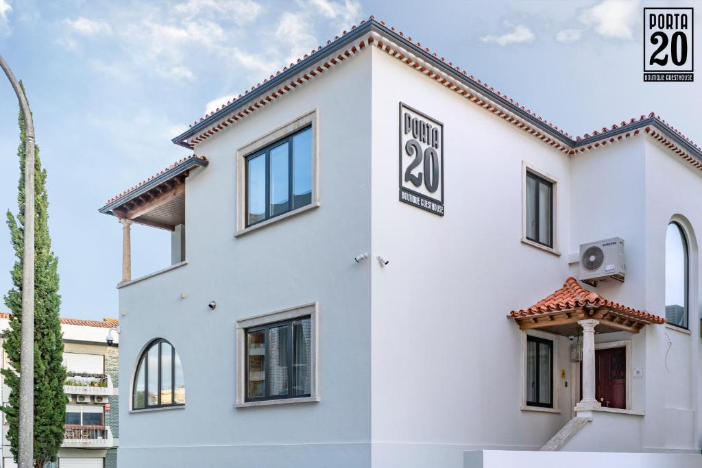 Porta 20 Boutique Guesthouse في ليريا: مبنى ابيض عليه لافته