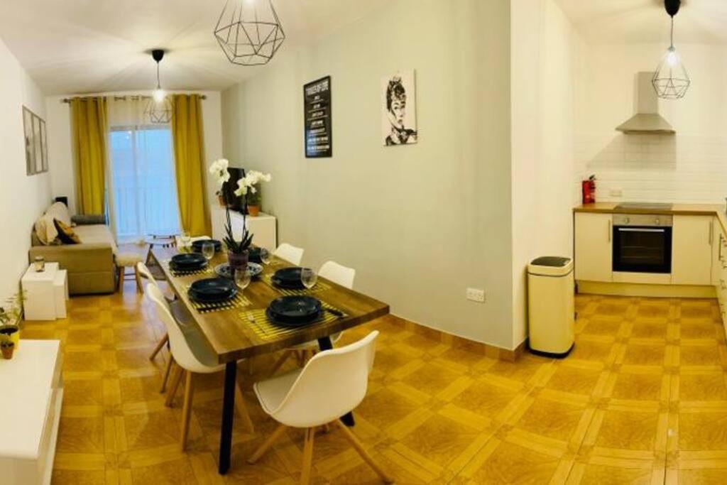 sala de estar con mesa y sillas y cocina en Porto Vita SeaView Apartment, en St Paul's Bay