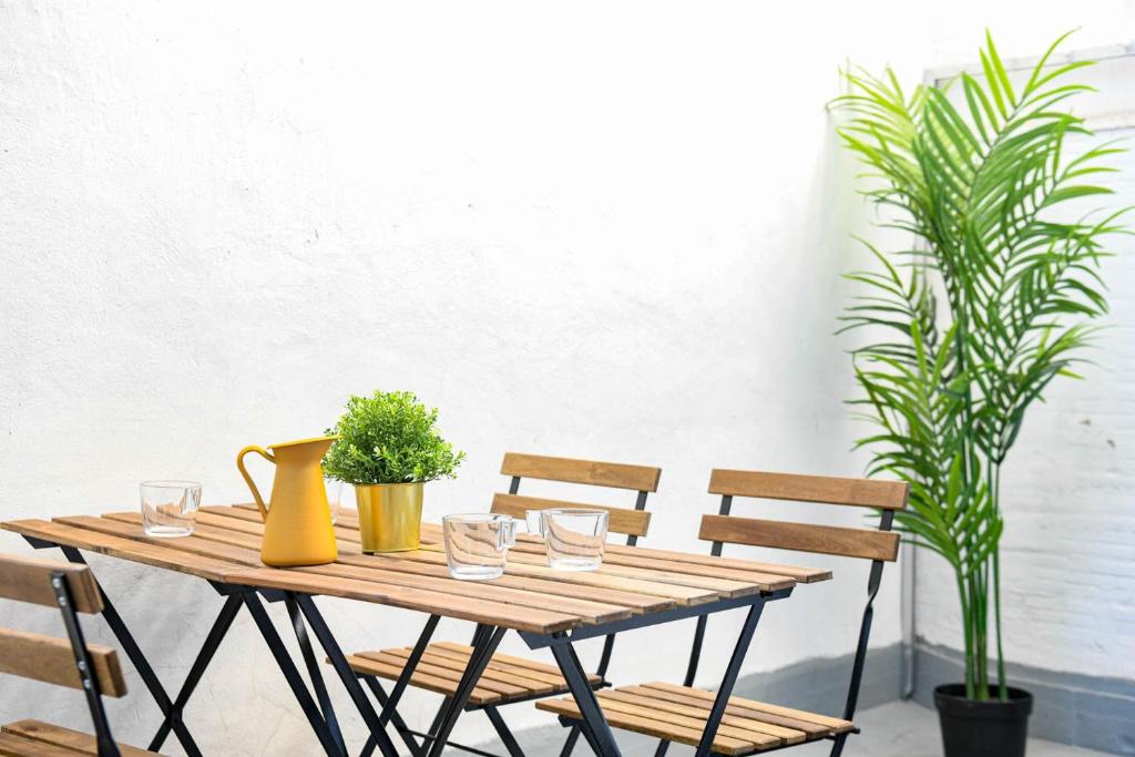 a wooden table with glasses and plants on it at Vieux-Port Grand appartement 2 ch avec terrasse in Marseille