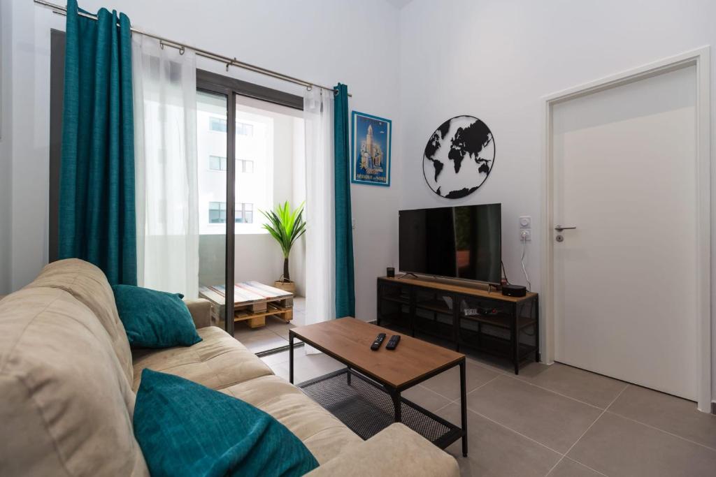 - un salon avec un canapé et une télévision dans l'établissement Le Mazenod - Appartement avec balcon et parking, à Marseille