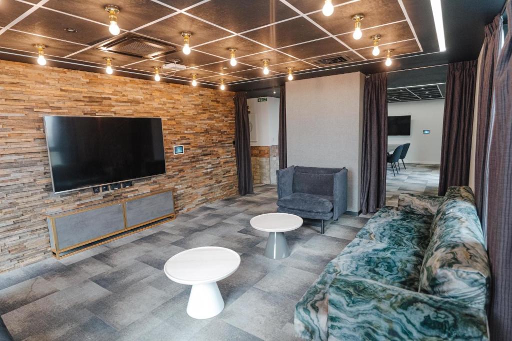 a living room with a couch and a flat screen tv at Studio Apartments and Ensuite Bedrooms with Shared Kitchen at Chapter Ealing right next to North Acton Tube Station in London