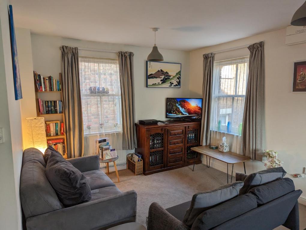 a living room with two couches and a flat screen tv at Namastay-Central Glastonbury in Glastonbury