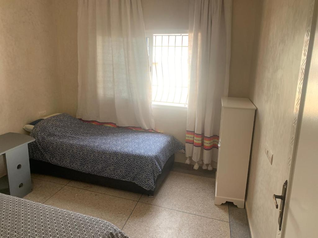 a small bedroom with two beds and a window at Appartement, tilila in Mirleft