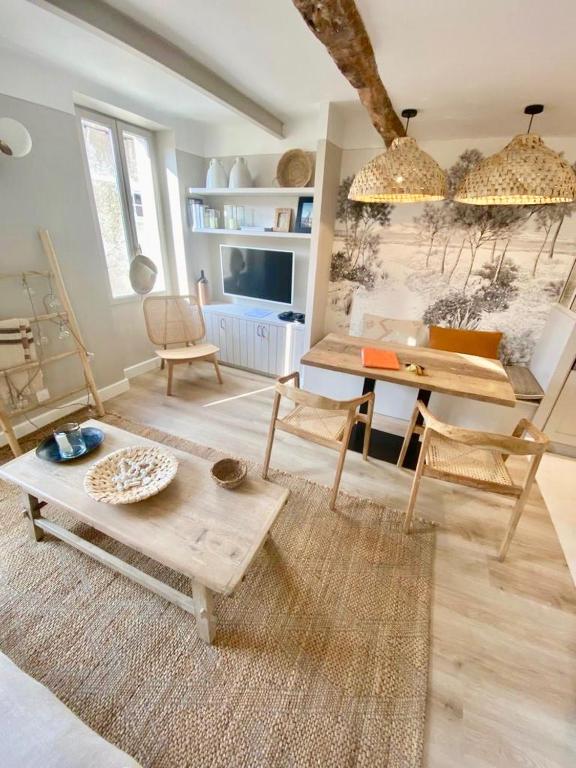 uma sala de estar com uma mesa e cadeiras em MAISON NOMADE Valbonne em Valbonne